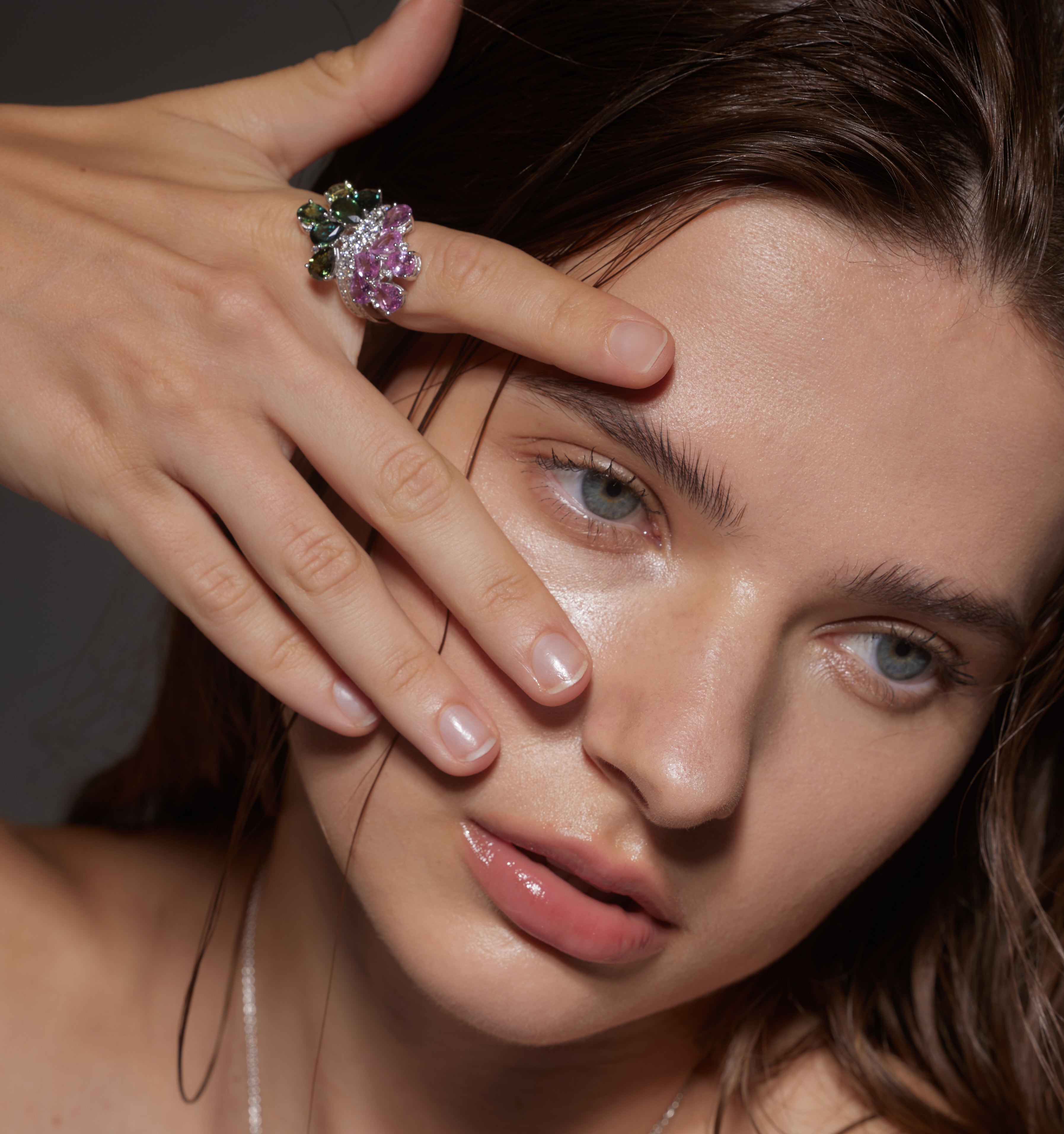 Model wears White Gold pink and green Twin Blossom Ring as she touches her face