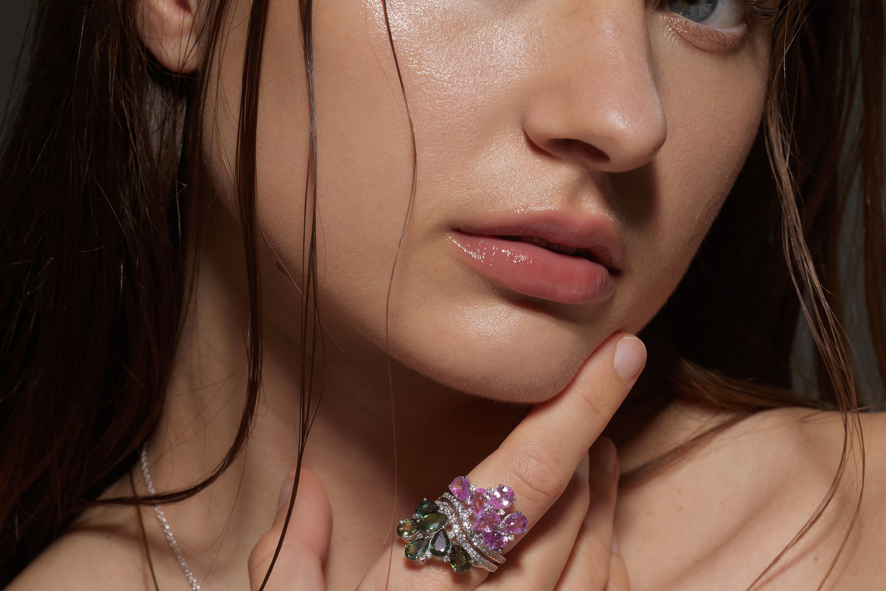 Model wears White Gold pink and green Twin Blossom Ring as she touches her face