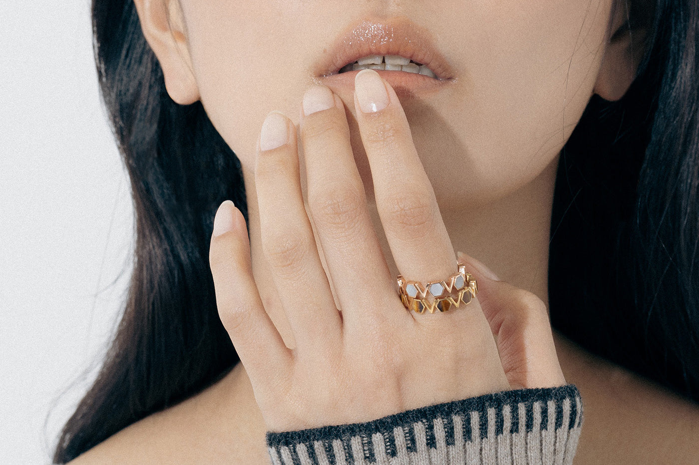 Model wears two Castle Bands, one White shell and the other Tiger’s Eye, as she touches her lips
