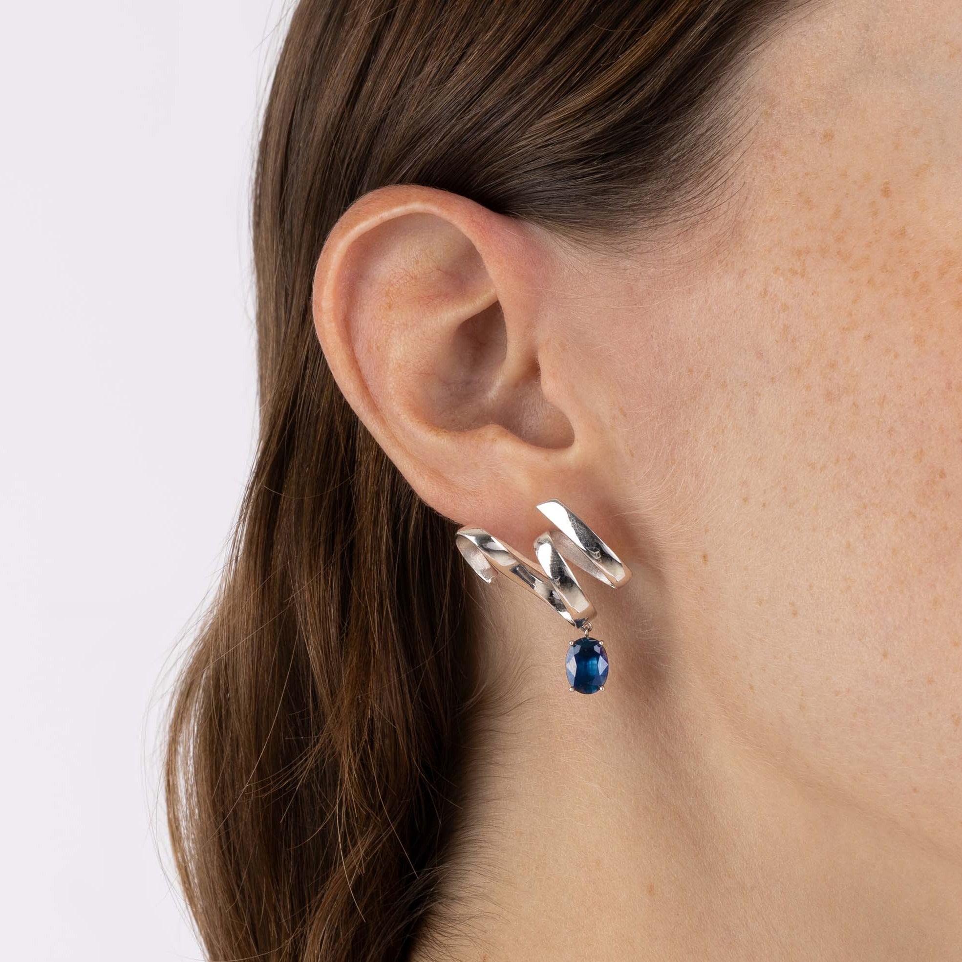 White Gold ribbon shaped Earrings with an oval shaped Blue Sapphire, Large - Model shot