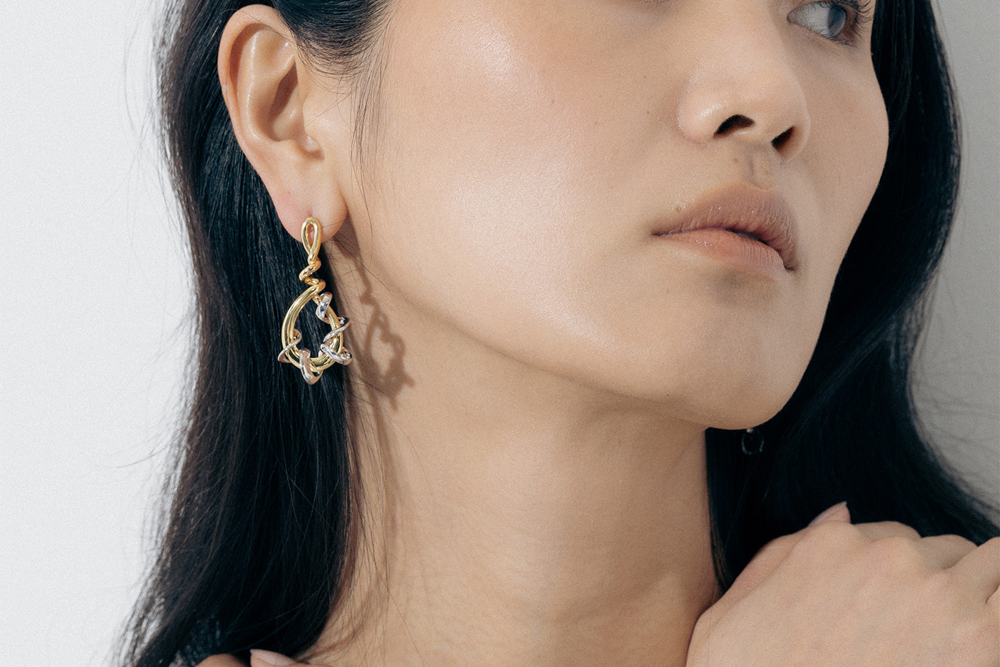Yellow Gold twisted drop shaped Earrings with white gold wrapped and twisted around it - Model shot