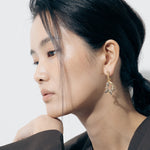 Yellow Gold twisted drop shaped Earrings with white gold wrapped and twisted around it - Model shot