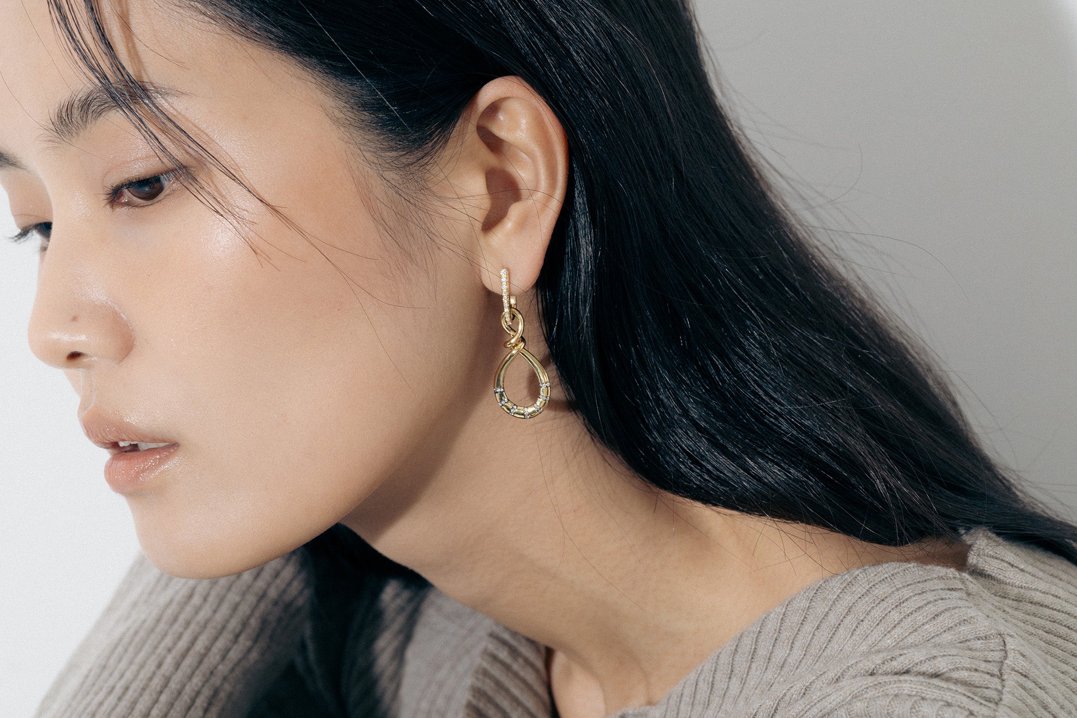 Yellow Gold Earrings in an uneven figure 8, with Rhodium Plated notches and Diamonds - Model shot
