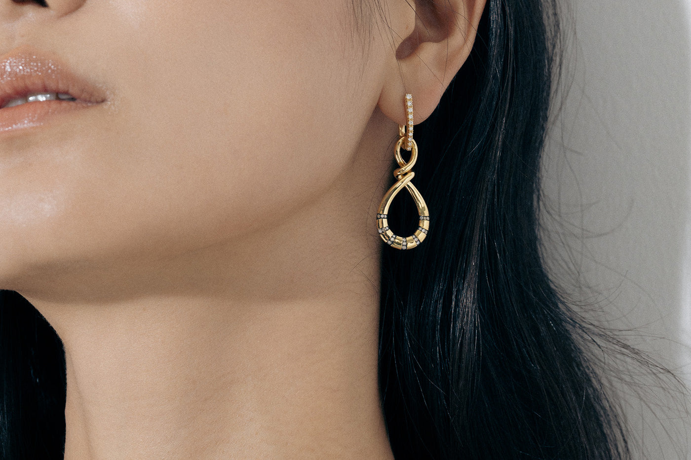 Yellow Gold Earrings in an uneven figure 8, with Rhodium Plated notches and Diamonds - Model shot